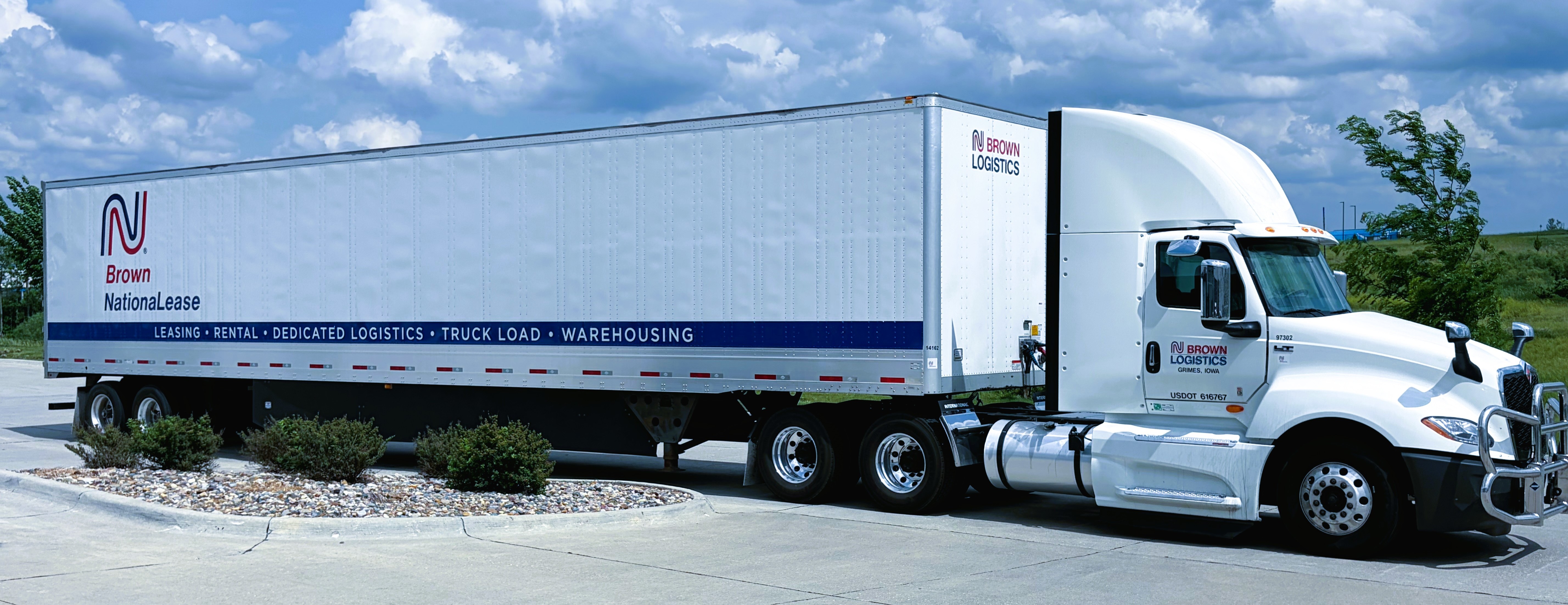 Brown Logistics semi-truck and trailer branded with fleet services: Leasing, Rental, Dedicated Logistics, Truck Load, and Warehousing